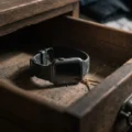A dusty smart watch left forgotten inside an old wooden drawer for a C1 English listening lesson on Listenglish.